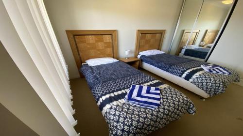 a room with two beds with blue and white blankets at Unit 64 Seafront Estate in Jurien Bay