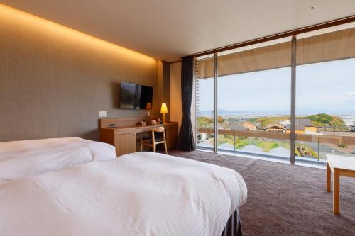 una camera d'albergo con due letti e una grande finestra di Hotel Nara Sakurai No Sato a Sakurai