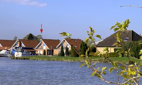 a row of houses next to a body of water at Ferienwohnung Landgang 25494 in Weener