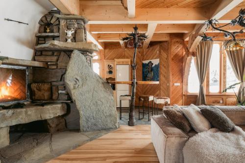 a living room with a stone fireplace and a couch at Art House Residence - Grand Luxury Villa - Mountain & Ski in Białka Tatrzańska