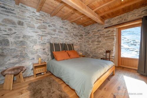a bedroom with a bed and a stone wall at Le Refuge Ibex - Chalet d'Alpage au coeur de la nature - 8 personnes in Orcières