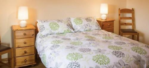 1 dormitorio con 1 cama con 2 mesitas de noche y 2 lámparas en ocean view cleggan en Cleggan