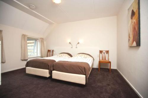 een slaapkamer met een groot bed en een raam bij Luxe vakantiehuis in Friesland 