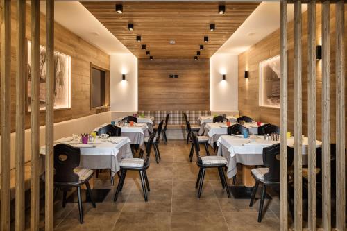 a dining room with white tables and chairs at Family Hotel Adriana in Ledro