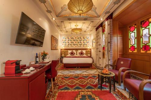 ein Hotelzimmer mit einem Bett, einem Tisch und Stühlen in der Unterkunft La Maison Arabe Hotel, Spa & Cooking Workshops in Marrakesch
