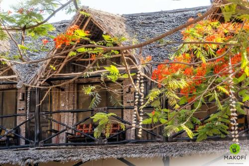an old house with flowers on the balcony at Makofi Guest House in Nungwi
