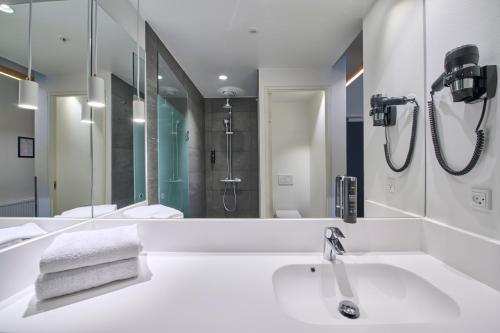 a bathroom with a sink and a large mirror at Zleep Hotel Vejle in Vejle