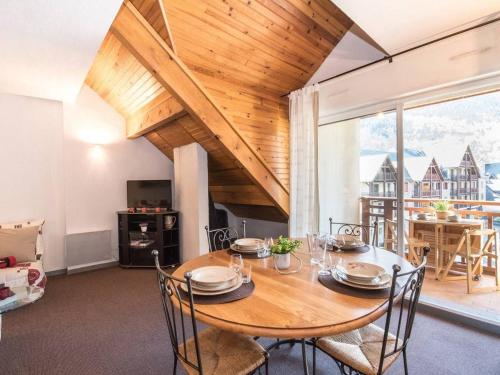 une salle à manger avec une table et des chaises en bois dans l'établissement Duplex ensoleillé pour 6 pers avec balcon, parking et proche des remontées mécaniques à Saint Lary - FR-1-296-265, à Saint-Lary-Soulan