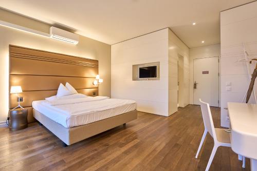a hotel room with a bed and a desk at Limmathof Baden - Boutique Haus & Spa in Ennetbaden