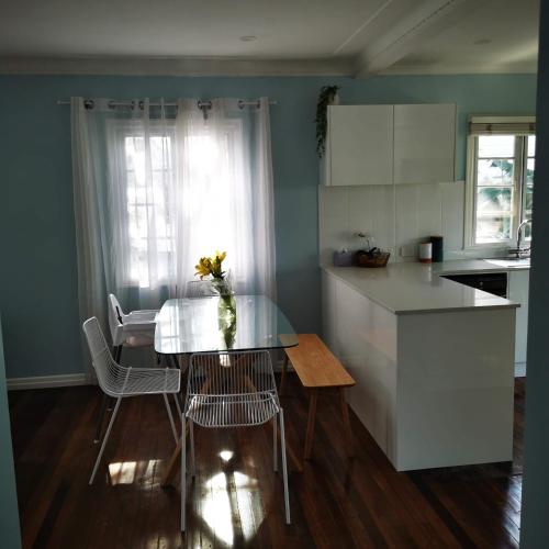 a kitchen with a table and chairs and a table and a kitchen with a counter at OXLEY Mineral Pool & Private Home suburbanSTAY in Brisbane