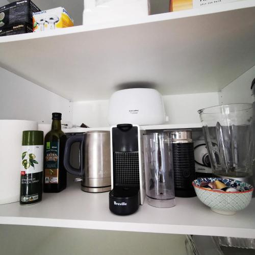 a kitchen shelf with a coffee maker and other appliances at OXLEY Mineral Pool & Private Home suburbanSTAY in Brisbane