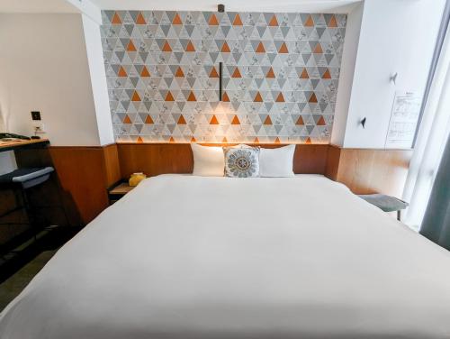 a bedroom with a large white bed in a room at CHECK inn Taichung Zhongshan in Taichung