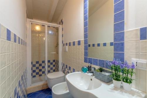 a blue tiled bathroom with a sink and a toilet at Villino Esse, Libero su 4 Lati più Dependance nel cuore della Versilia in Marina di Pietrasanta