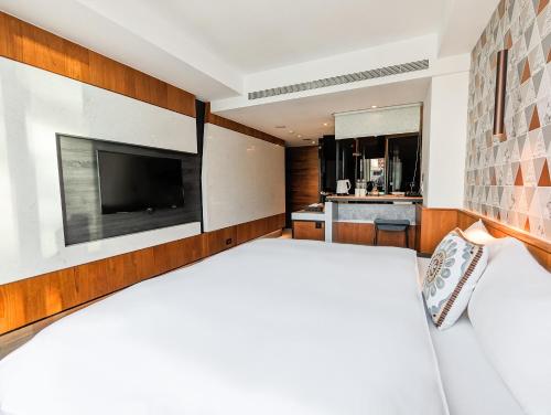 a bedroom with a large bed and a television at CHECK inn Taichung Zhongshan in Taichung