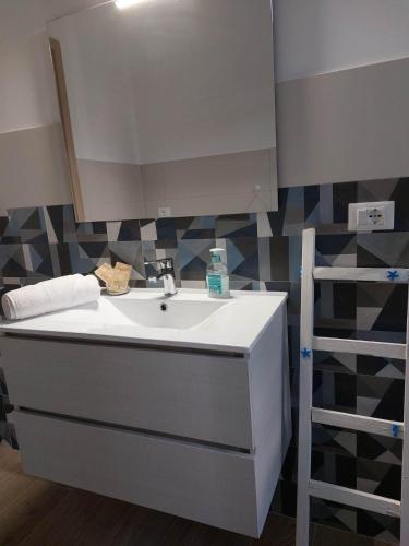 a bathroom with a sink and a mirror at Blue Sicily Apartment in Roccalumera