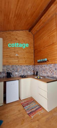 a kitchen with a counter with a sign on the wall at Guesthouse and Cottage Nicolo in Stepantsminda