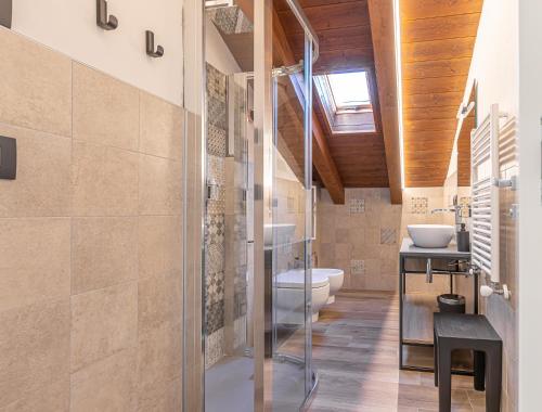 uma casa de banho com uma cabina de duche em vidro e um WC. em Hotel Mon Émile em Aosta