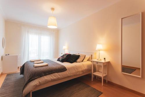 sypialnia z dużym łóżkiem i lustrem w obiekcie Best Houses 13 - Peniche Great Location w mieście Peniche