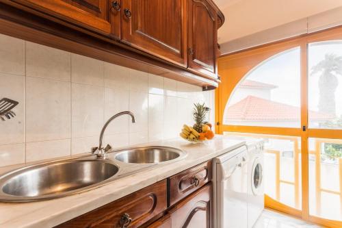 a kitchen with a stainless steel sink and a window at Best houses 14: Close to the Beach Apartment in Peniche