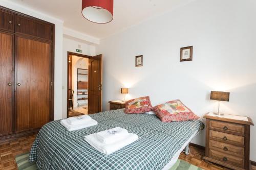 a bedroom with a bed with two towels on it at Best houses 14: Close to the Beach Apartment in Peniche
