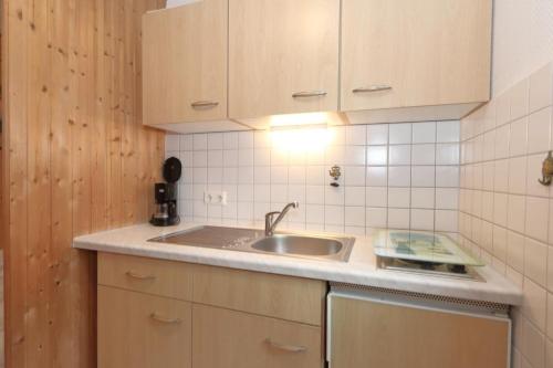 uma cozinha com um lavatório e uma bancada em Solveig-Maike-03 em Westerland
