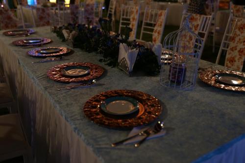 a long table with plates and silverware on it at Clarks Inn Suites Raipur in Raipur