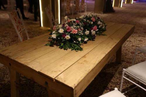 a wooden table with a bouquet of flowers on it at Clarks Inn Suites Raipur in Raipur