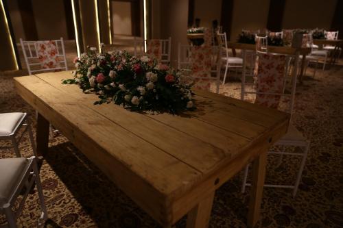 a wooden table with a bouquet of flowers on it at Clarks Inn Suites Raipur in Raipur