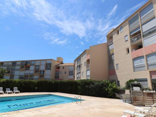 une piscine devant un immeuble dans l'établissement Spacieux 2 pièces avec terrasse, piscine et ascenseur à 400m de la plage - FR-1-307-168, au Grau-du-Roi