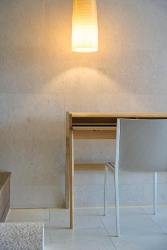 a table with a chair and a light on top at Limmathof Baden - Boutique Haus & Spa in Ennetbaden