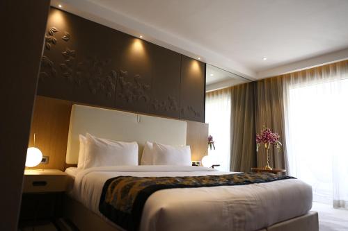 a bedroom with a large bed and a large window at Clarks Inn Suites Raipur in Raipur