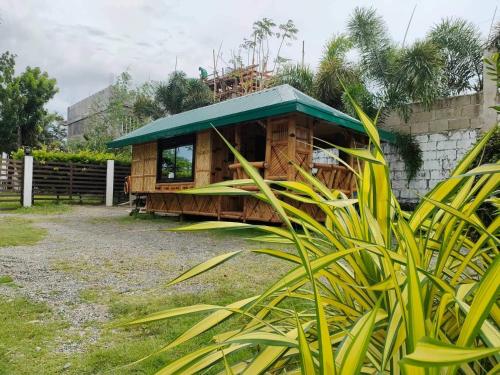 a wooden building with a green roof at Casa Herminia Baler in Baler