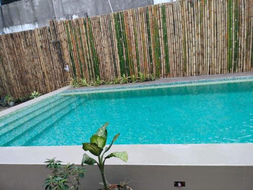 a swimming pool in front of a wooden fence at Casa Herminia Baler in Baler