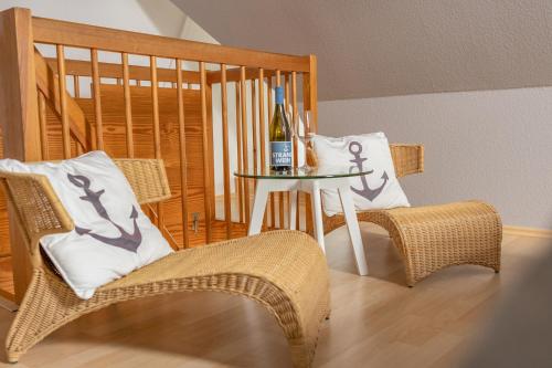 Habitación con mesa, sillas y botella de vino. en Surf Break, en Sankt Peter-Ording