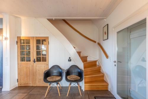 two black chairs in a hallway with a staircase at Andrea in Aventoft
