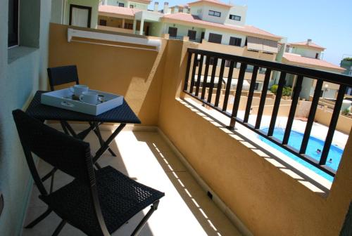 d'un balcon avec une table, des chaises et une piscine. dans l'établissement Cerca del mar 500mbs WIFI, à Puertito de Güímar