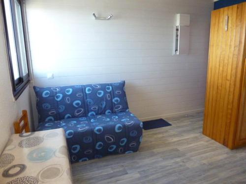 un soggiorno con un divano blu in una stanza di Arette : Apt 4/5 pers, au pied des pistes, ascenseur, parking, micro-ondes/grill - FR-1-602-107 ad Arette
