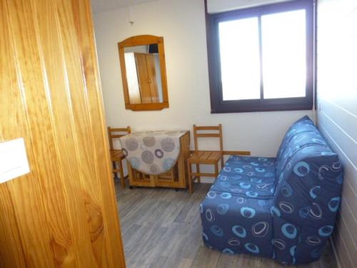 un soggiorno con un divano blu e un tavolo di Arette : Apt 4/5 pers, au pied des pistes, ascenseur, parking, micro-ondes/grill - FR-1-602-107 ad Arette