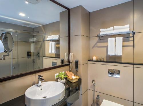 a bathroom with a sink and a mirror at WILD AVENUE RESORT & SPA in Thekkady