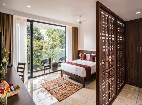 a hotel room with a bed and a large window at WILD AVENUE RESORT & SPA in Thekkady