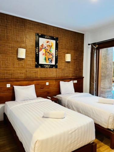 duas camas num quarto de hotel com em Milky Way Homestay Canggu em Canggu