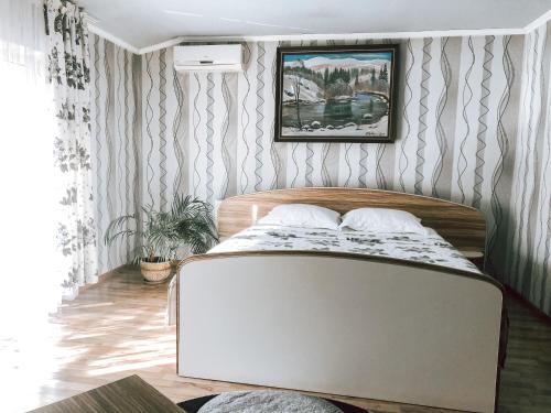 a bedroom with a bed in a room with wallpaper at Koral Hotel in Verkhniy Koropets