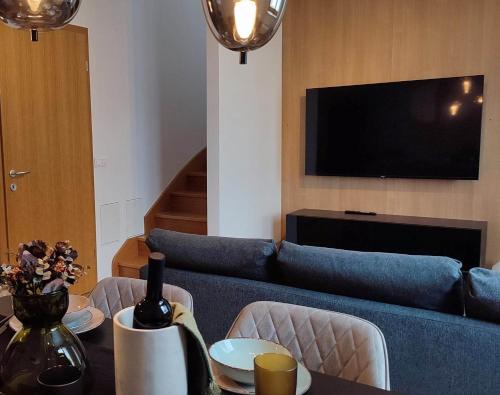a living room with a blue couch and a tv at Pohorje Pearl Lux, 2-floor apartment in Pohorje