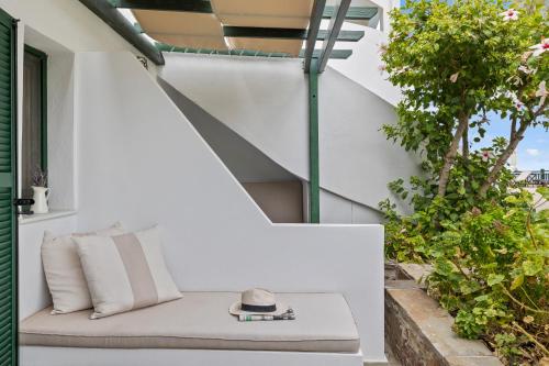 a white bench with a hat and a book at Erofili Beach Hotel in Armenistis