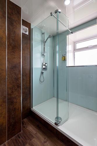 a shower with a glass door in a bathroom at The Melbreak Hotel in Great Clifton
