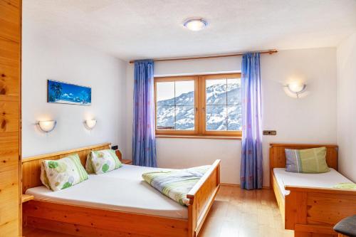1 dormitorio con 2 camas y ventana en Rofanblick en Gattererberg