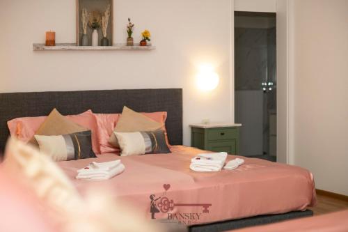 - une chambre avec un lit rose et des serviettes dans l'établissement DUPLEX LOFT IN LUGANO CENTER with Garden, Wi-Fi -By EasyLife Swiss, à Lugano