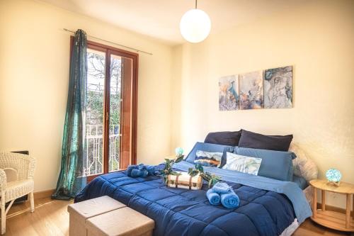Un dormitorio con una cama azul y una ventana en PURA VIDA APARTMENT Porto Torchio, en Manerba del Garda