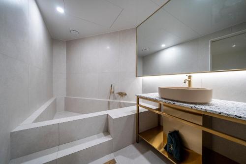 a bathroom with a tub and a sink at Hotel Classy in Seoul