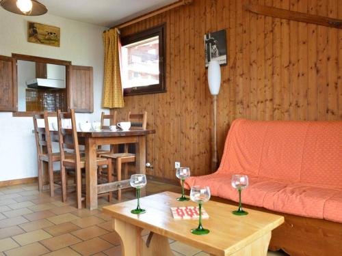 ein Wohnzimmer mit einem Sofa und einem Tisch mit Weingläsern in der Unterkunft Appartement Le Grand-Bornand, 3 pièces, 6 personnes - FR-1-241-62 in Le Grand-Bornand